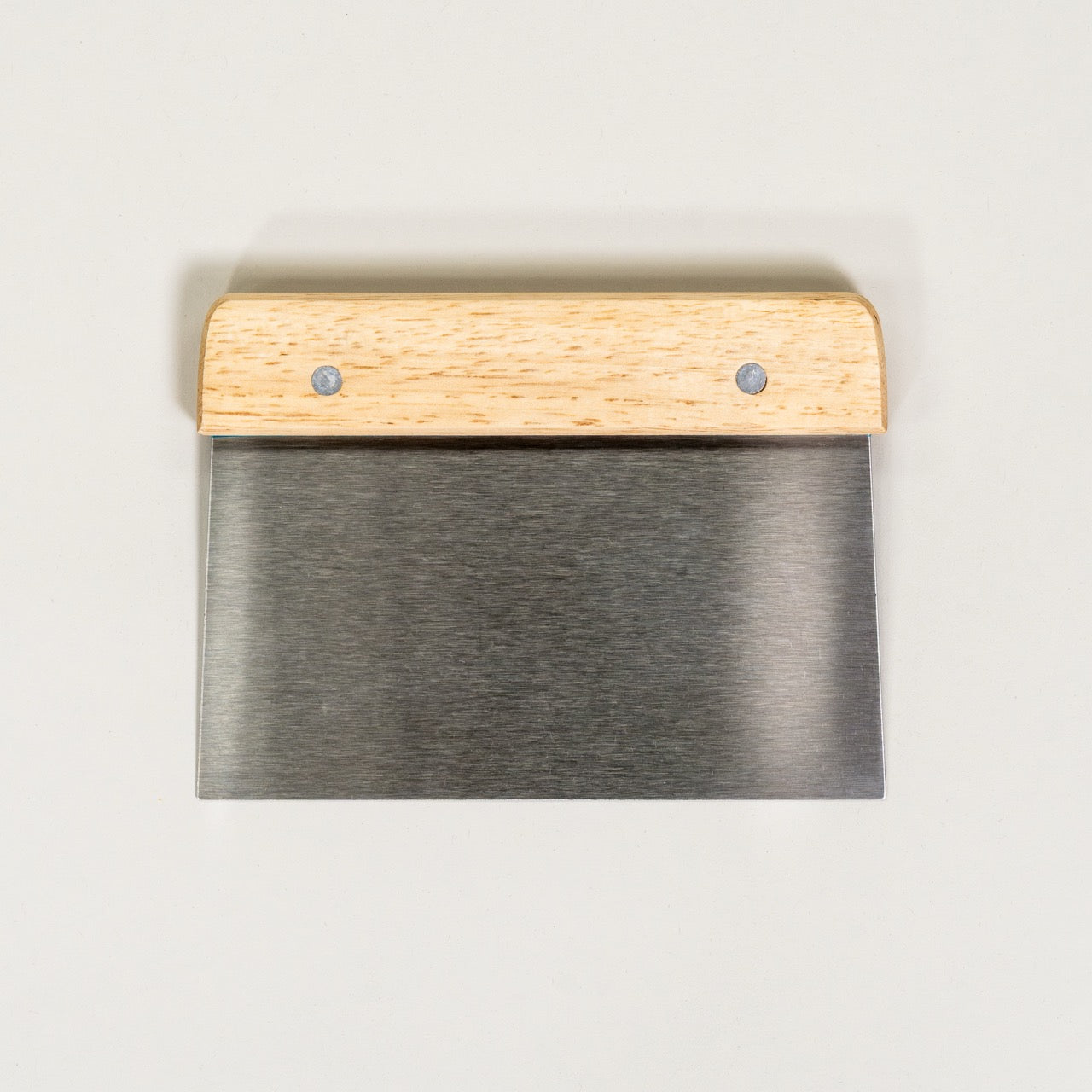 A stainless steel dough scraper with a wooden handle, viewed from a front angle against a white background.