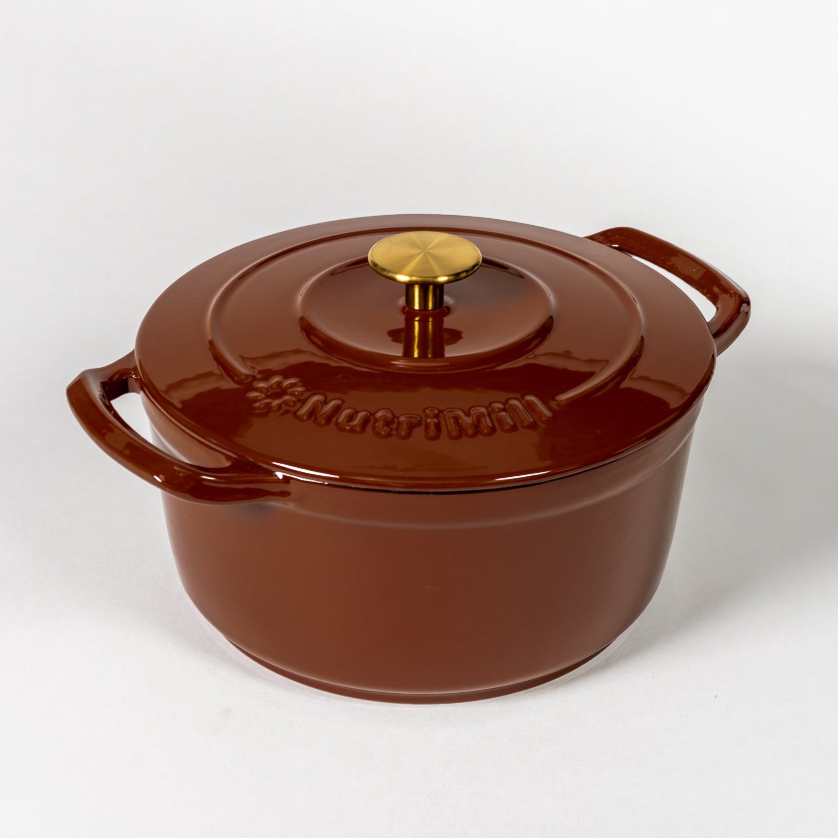 Reddish brown enameled cast iron Dutch oven with a gold knob on a white background