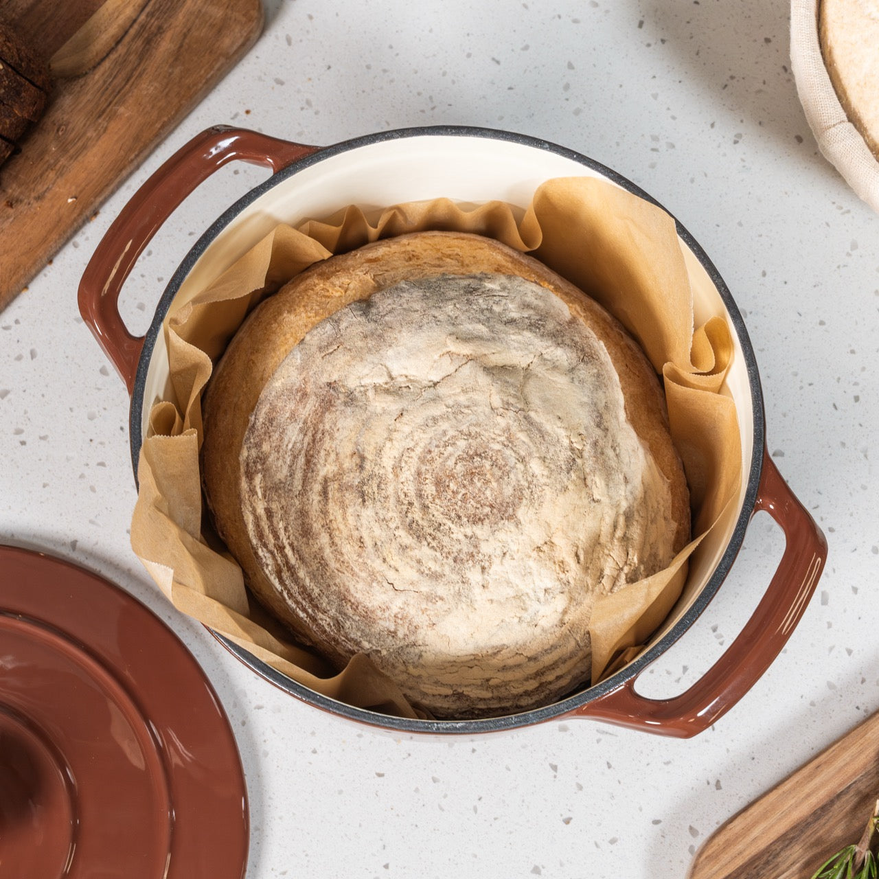 Loaf of bread in a cast iron pot on a kitchen counter