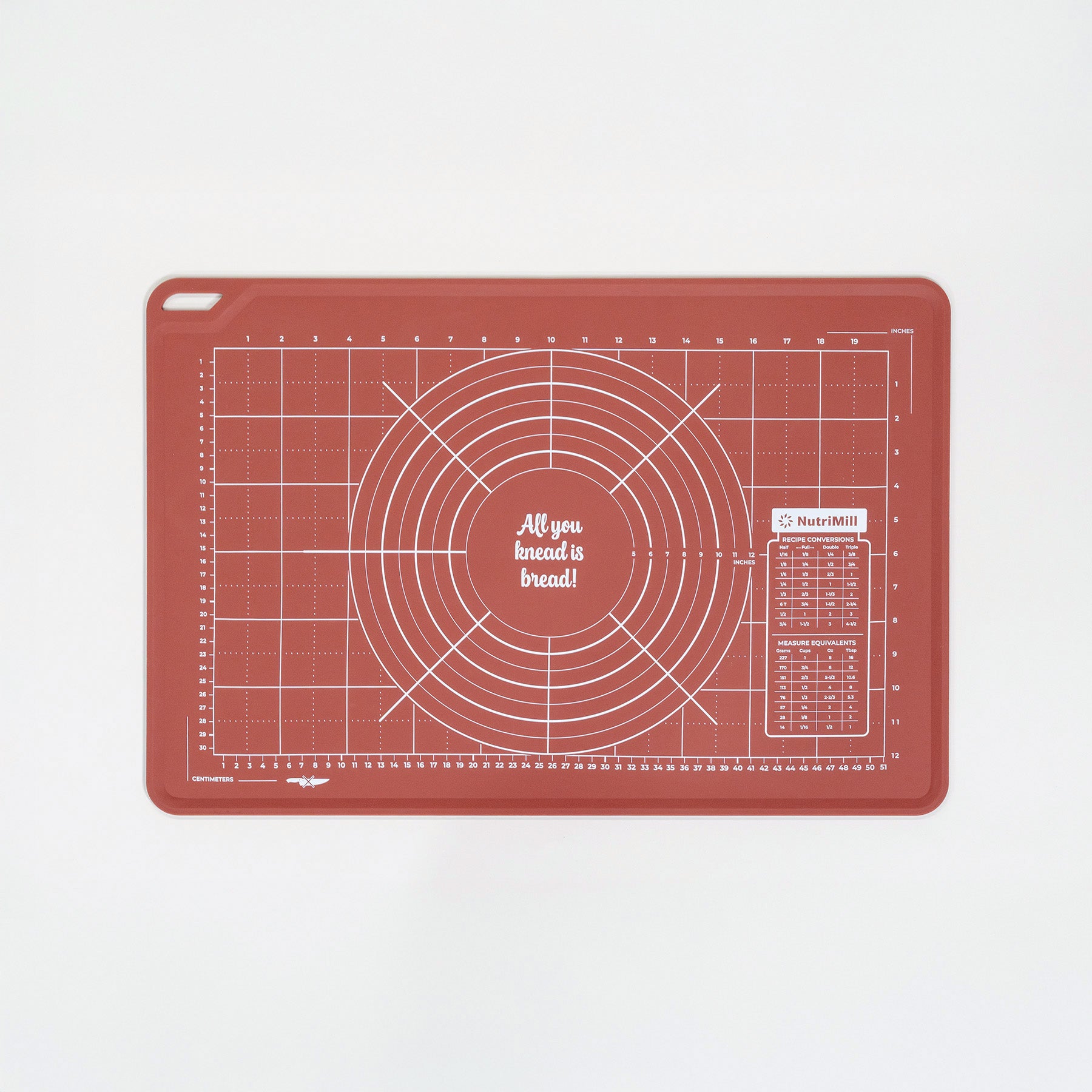 Red silicone dough mat with grid and circular measurements on a white background
