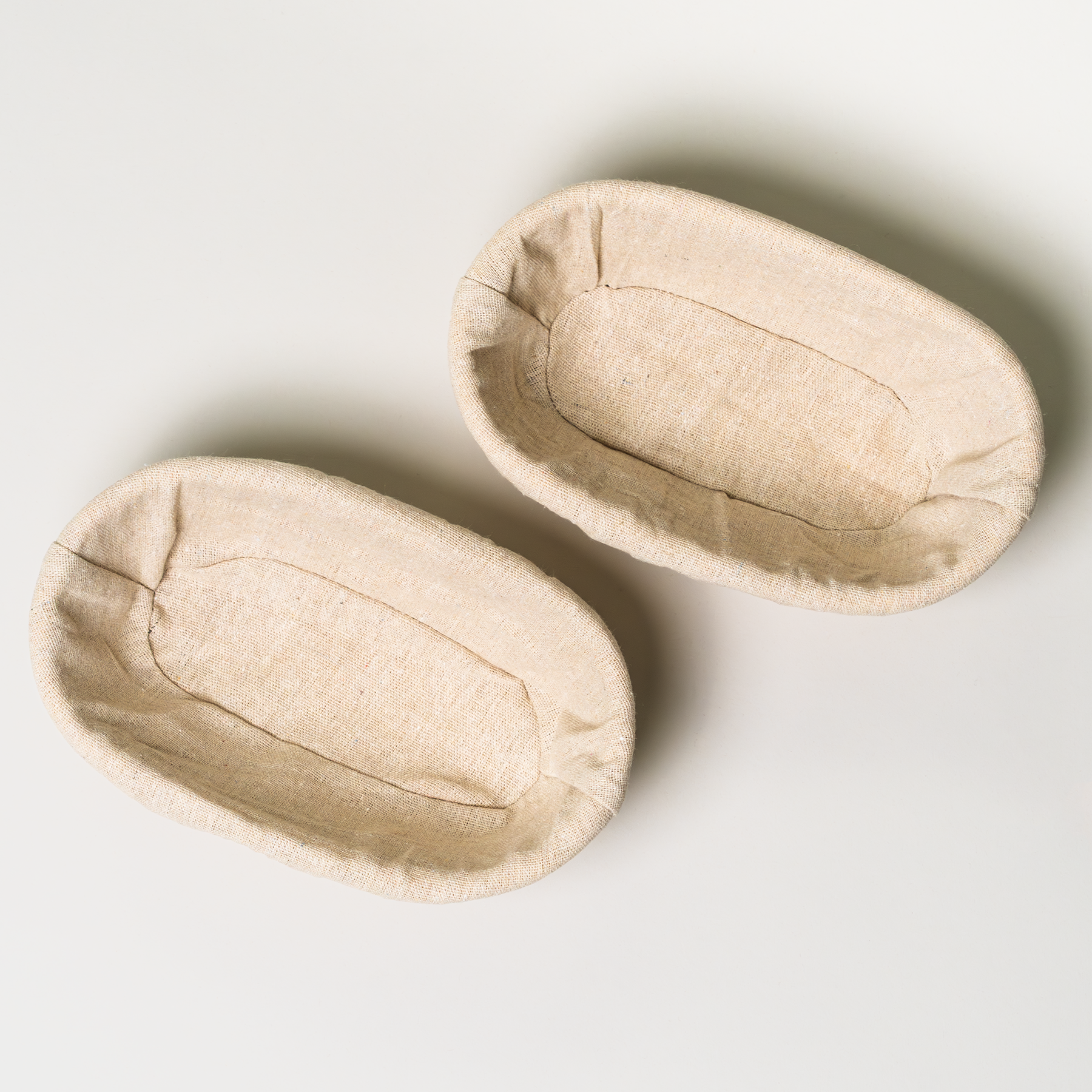 Top view of 2 NutriMill banneton baskets on a grey background