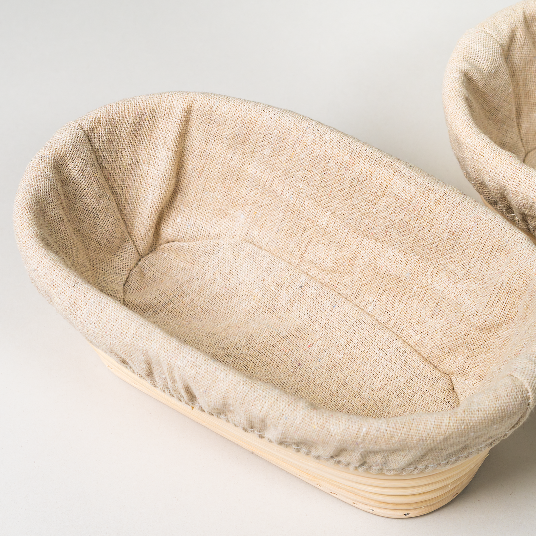 Up close of a NutriMill banneton basket on a grey background