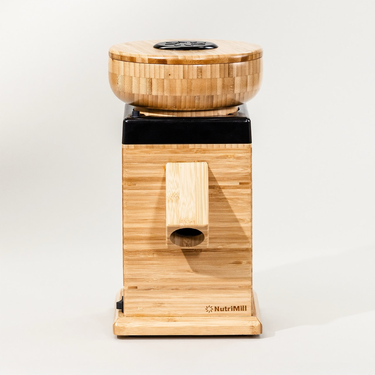 A Black NutriMill Harvest grain mill made of bamboo, displayed on a white background, featuring a adjustable texture control knob.