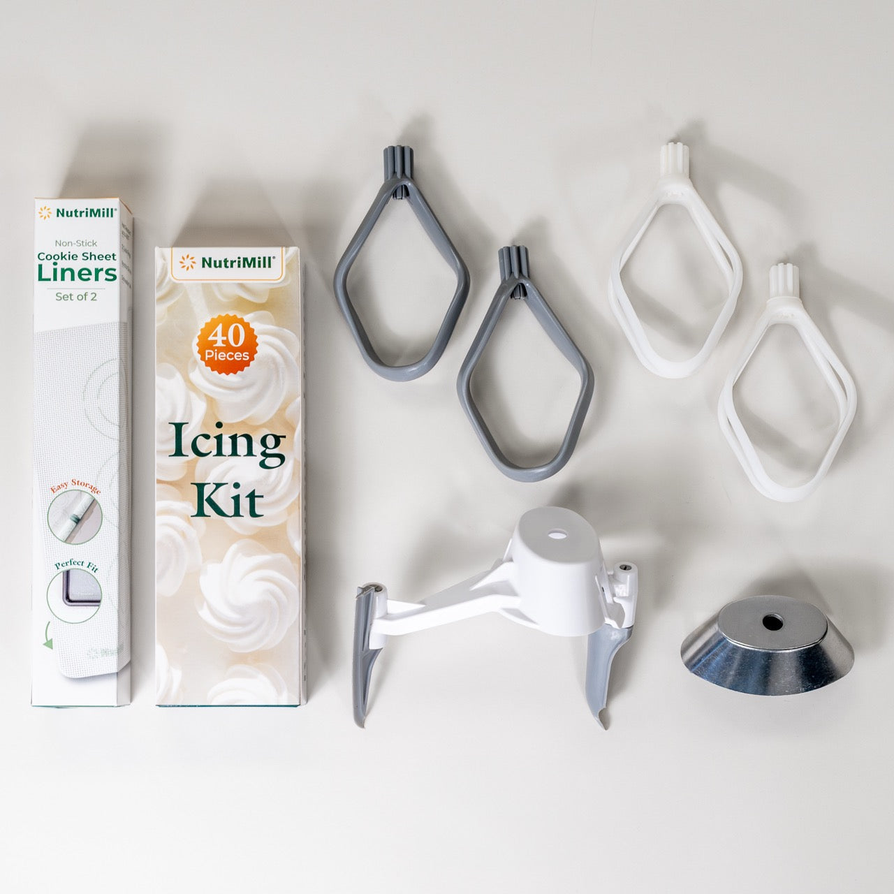 A collection including cookie paddles, cake paddles, a bowl scraper, metal whip driver, cookie sheet liners, and an icing kit.