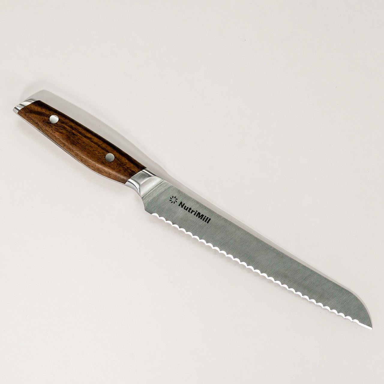 An 8-inch NutriMill bread knife with a stainless steel blade and a walnut handle.