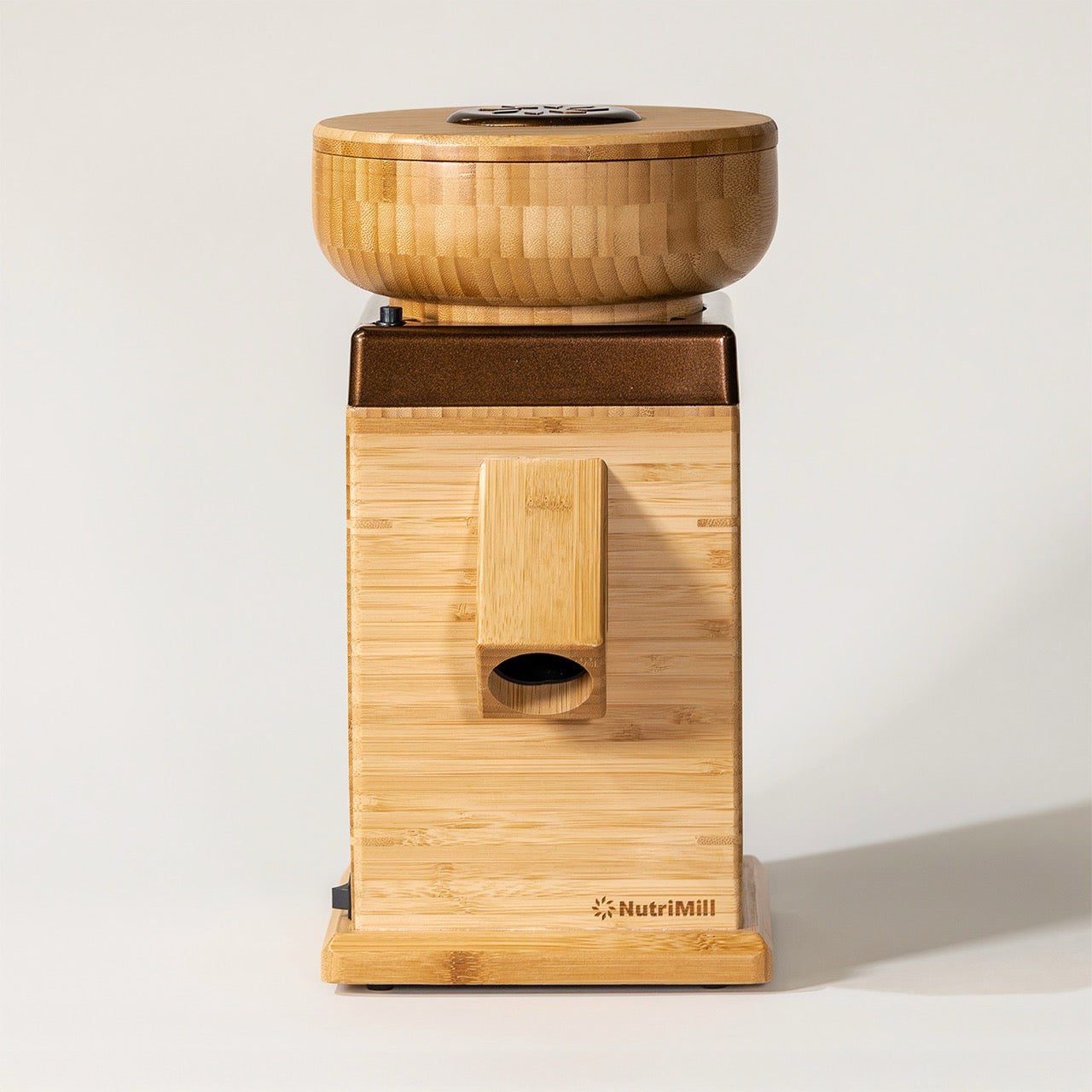 A NutriMill Harvest flour mill made of bamboo, displayed on a white background, featuring a adjustable texture control knob.