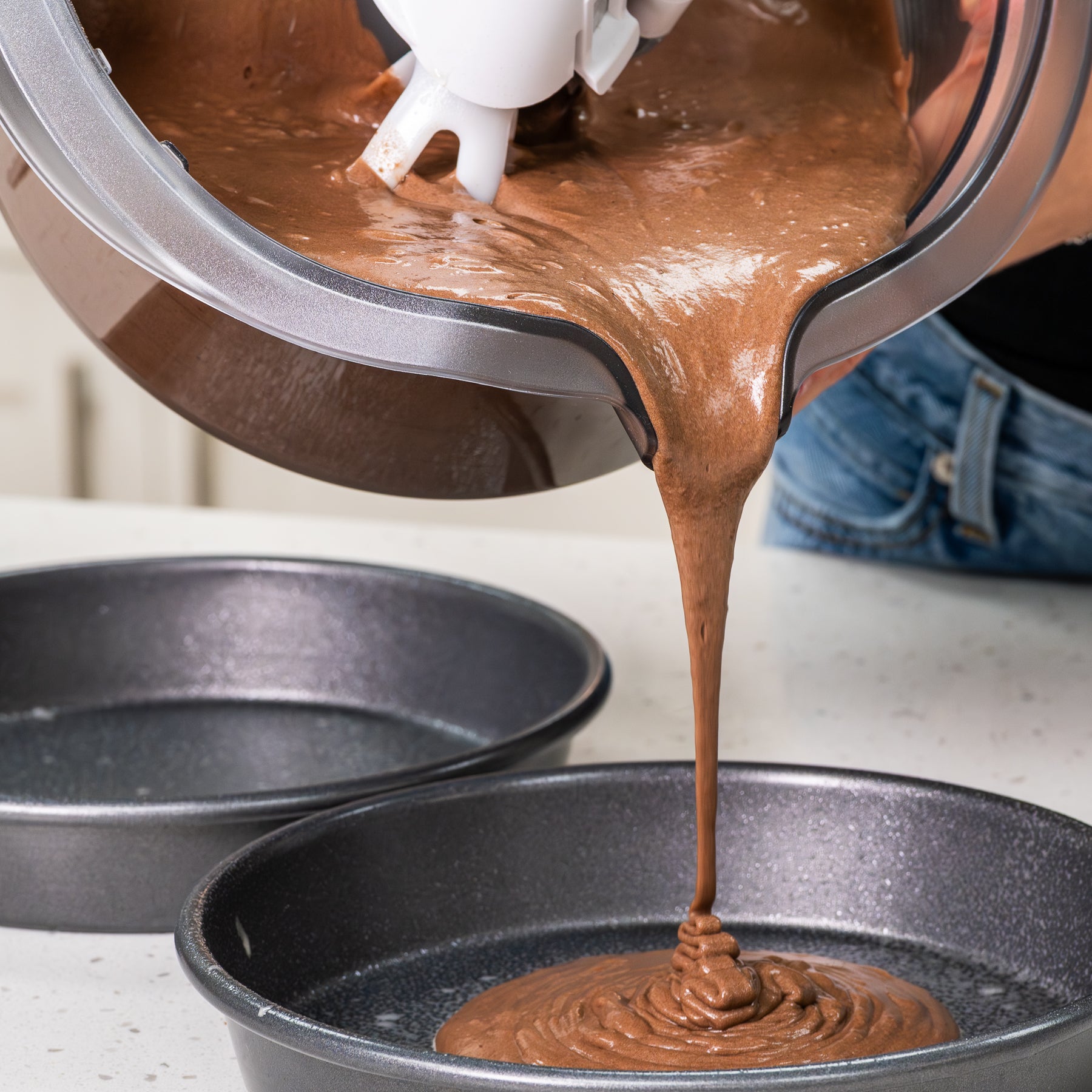 Chocolate batter being poured into a baking pan