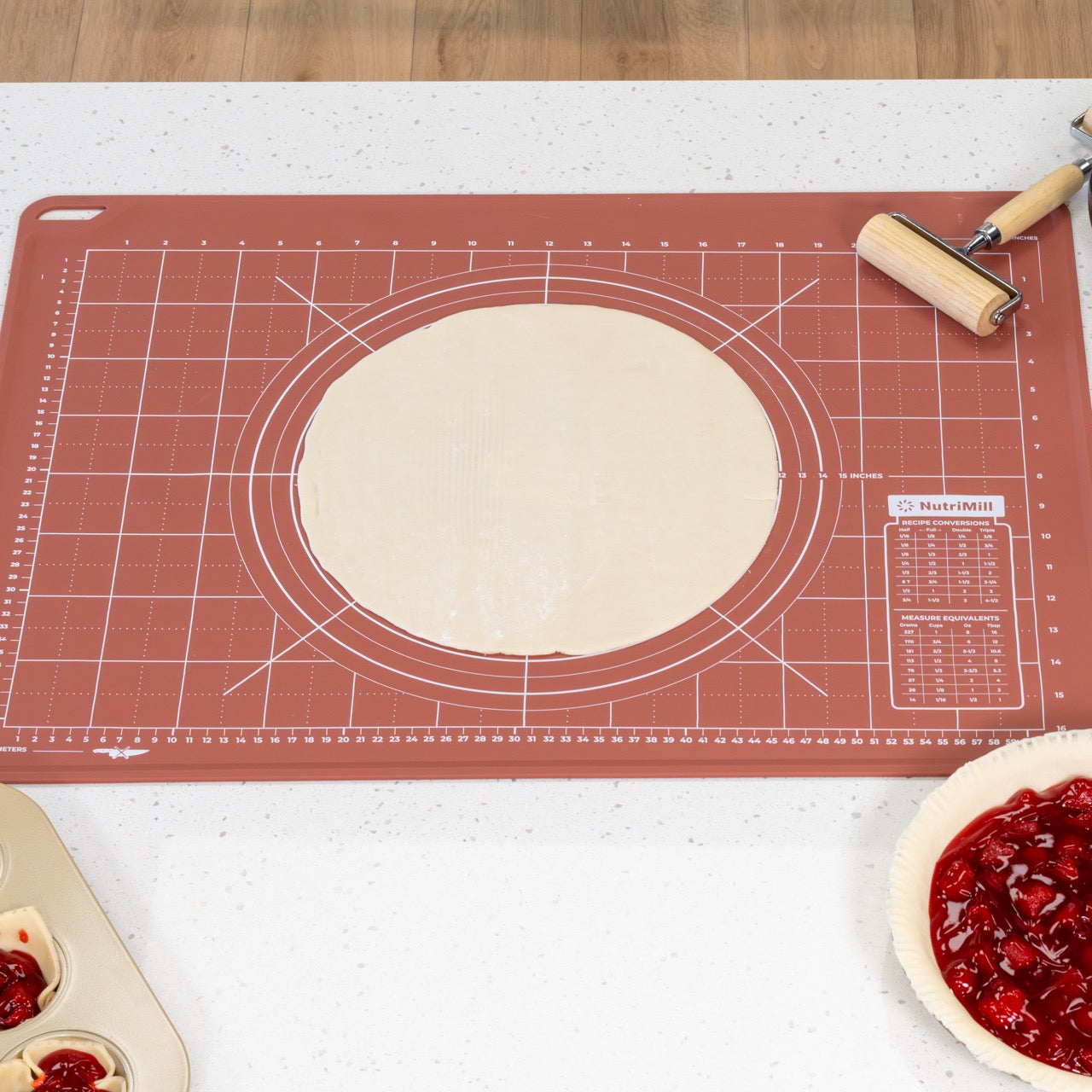Pie crust on a silicone dough mat with pie filling and roller nearby.