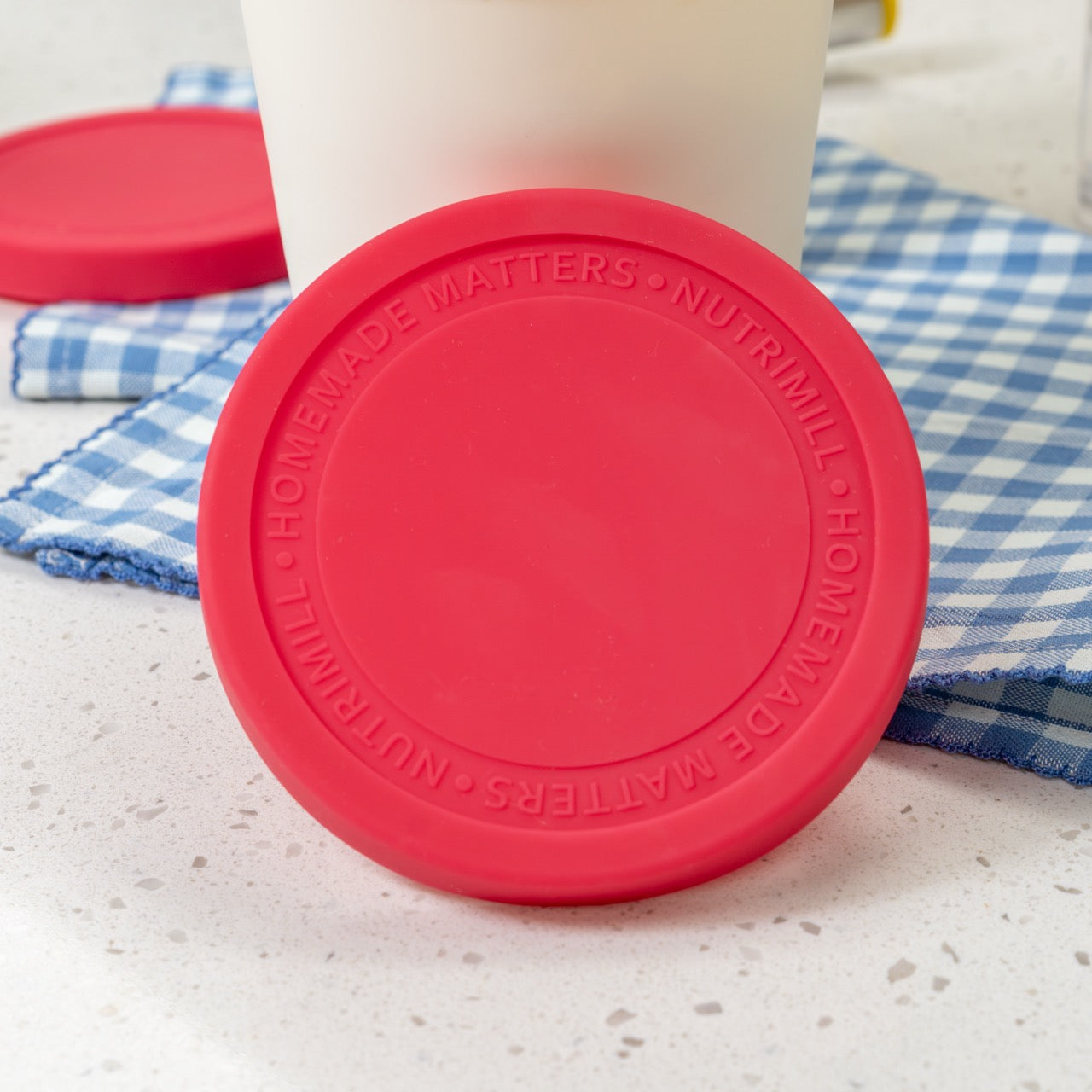 Red lid with 'NUTRIMILL' branding on a countertop