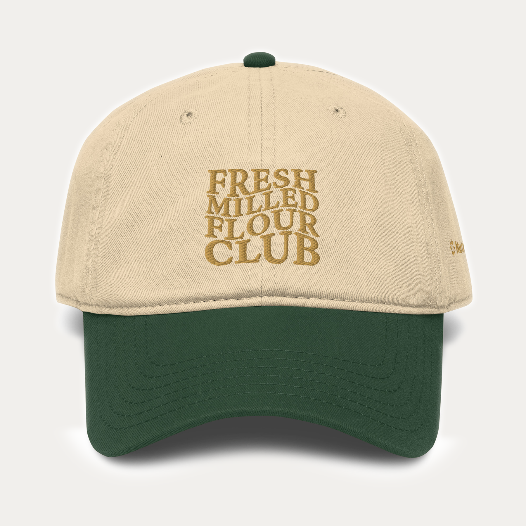 NutriMill beige and green cap with 'Fresh Milled Flour Club' text on a light gray background