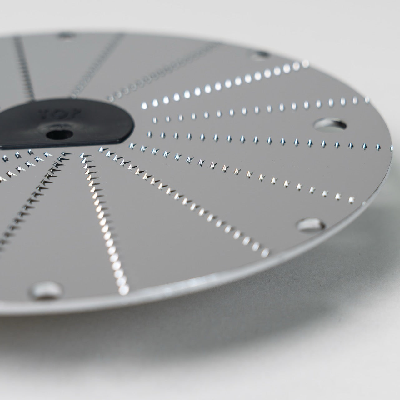 Up close of the Magimix horseradish disk on a grey background