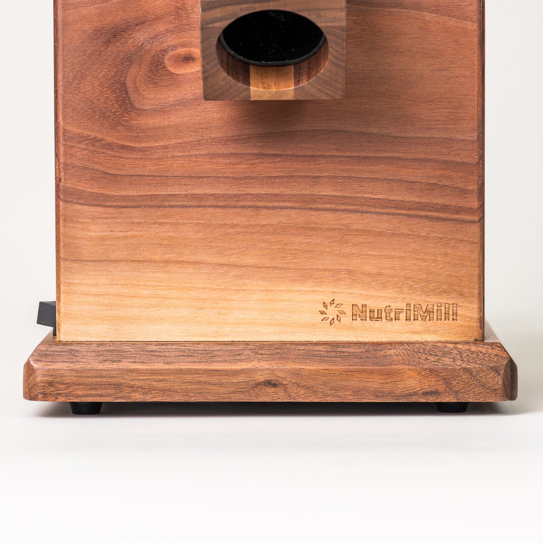 Close up of NutriMill harvest walnut grain mill with NutriMill logo on grey background