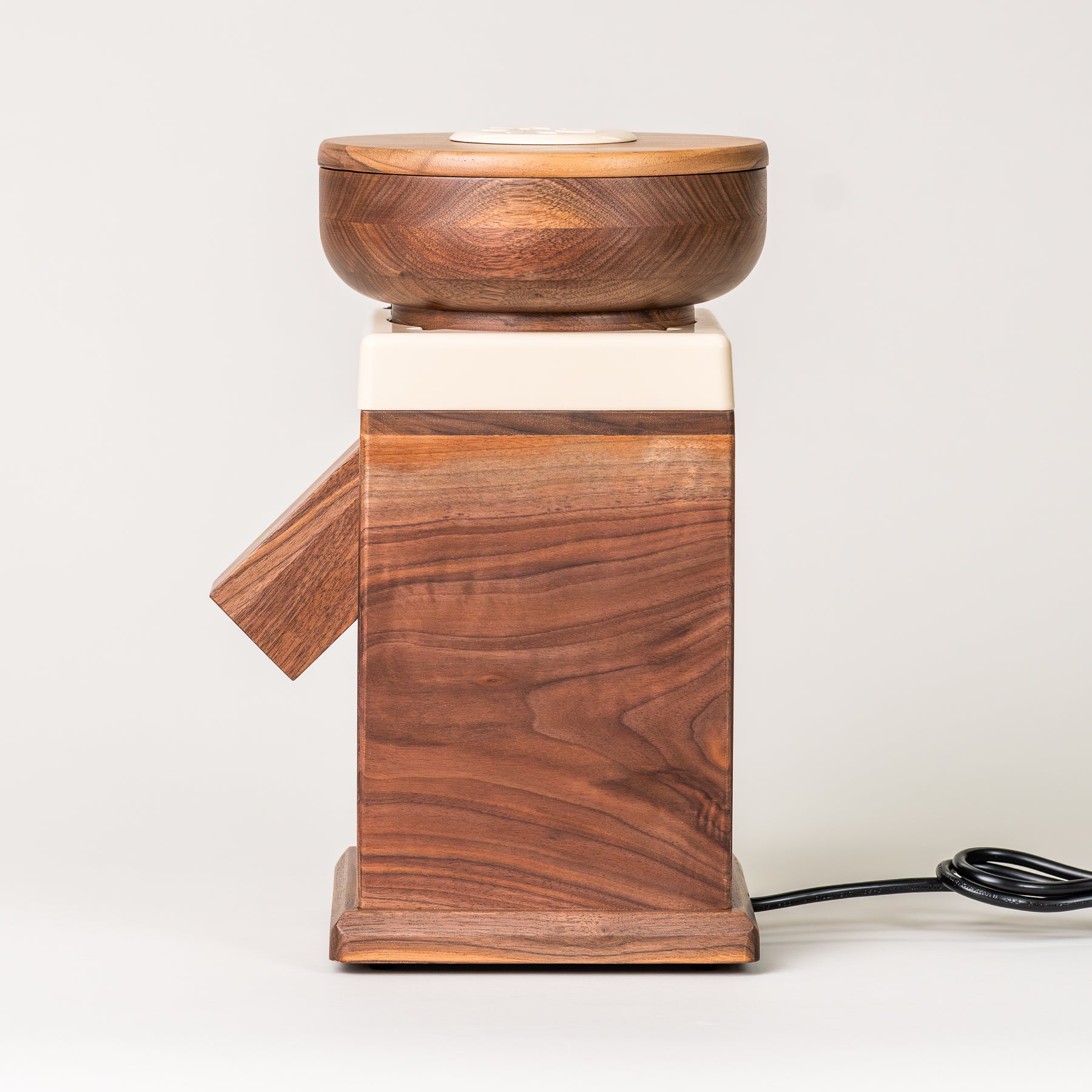 Side angle of NutriMIll harvest walnut grain mill with cream-colored trim on grey background