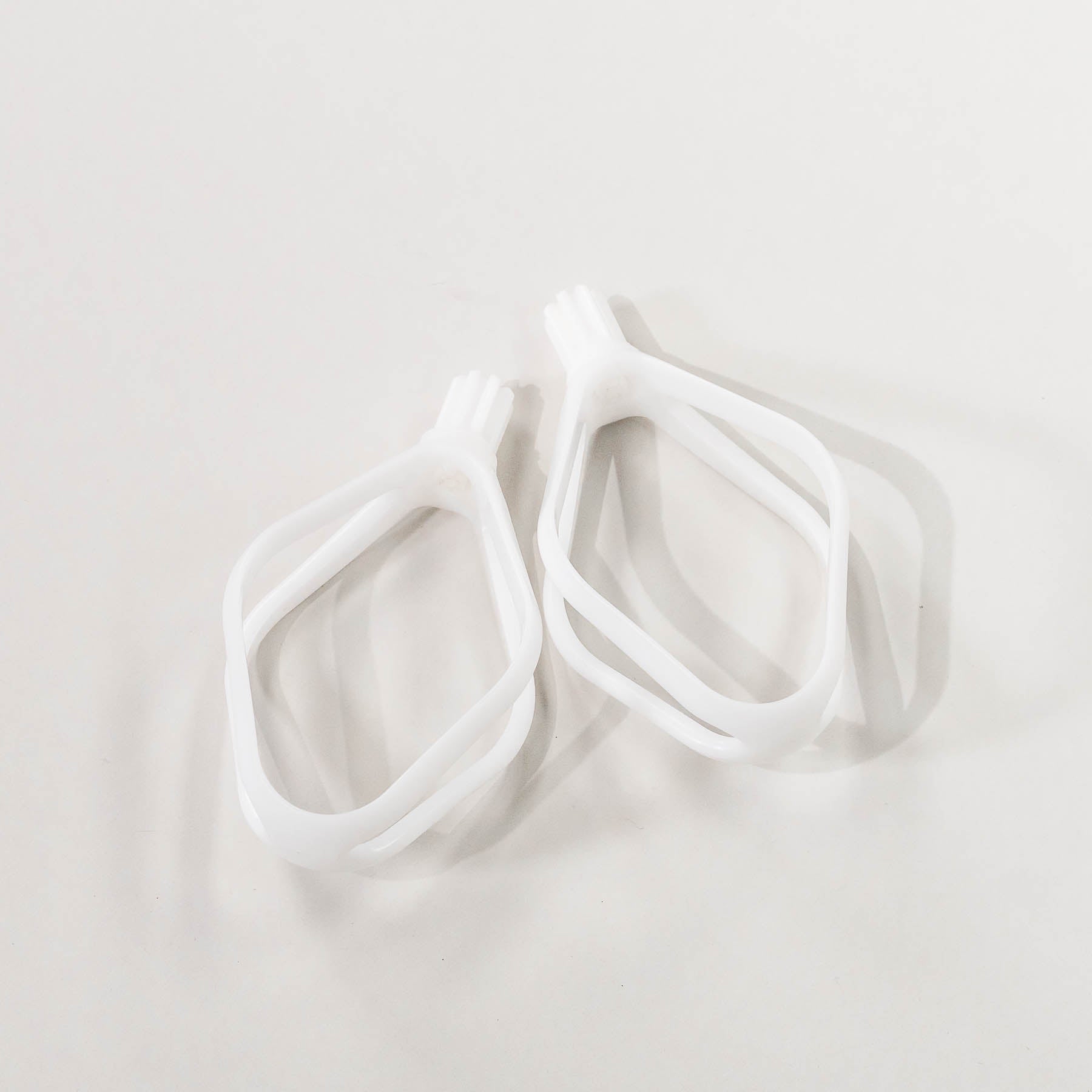 A pair of white plastic cake paddles, designed for mixing batters.