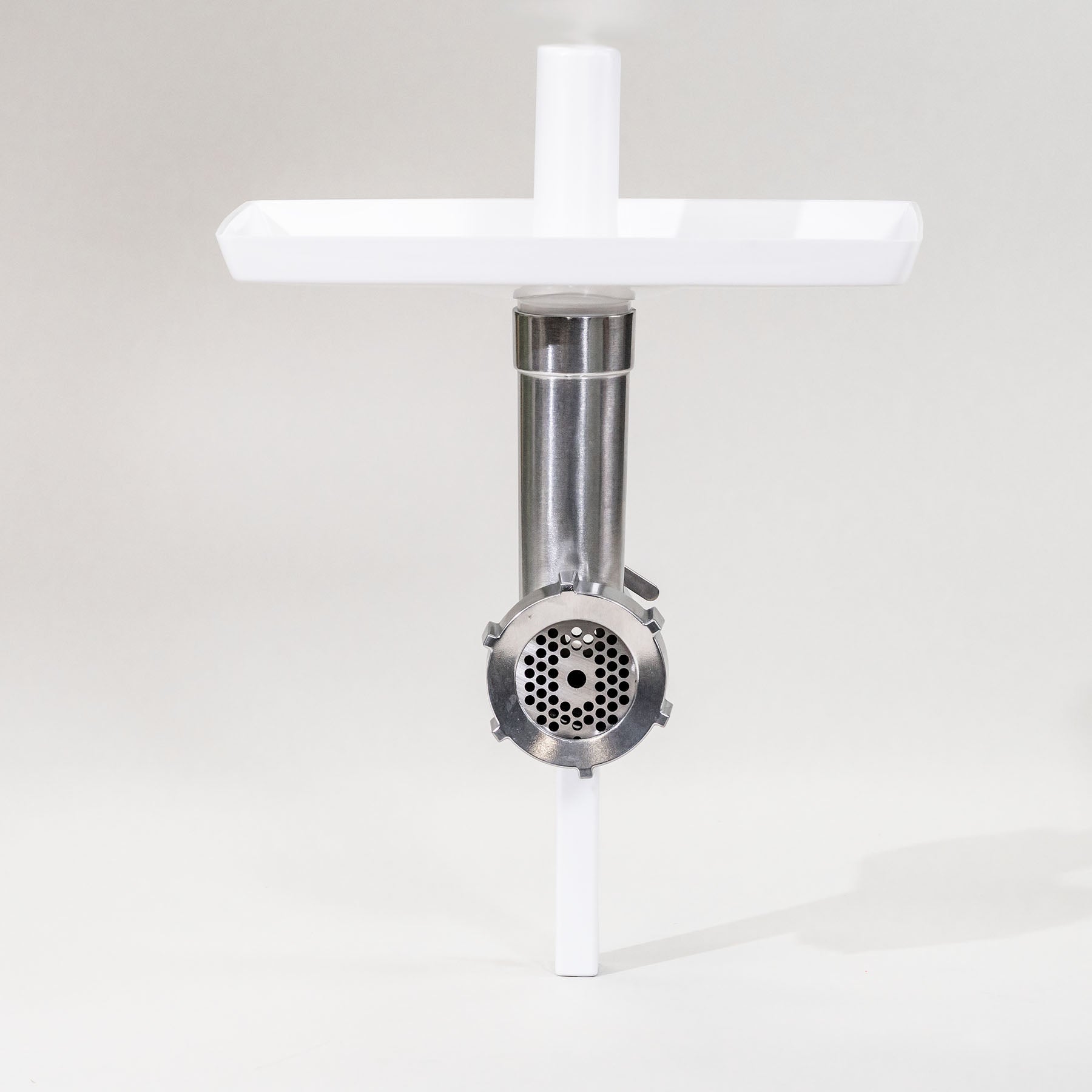 A Bosch meat grinder attachment with a white tray on top, set against a neutral background.