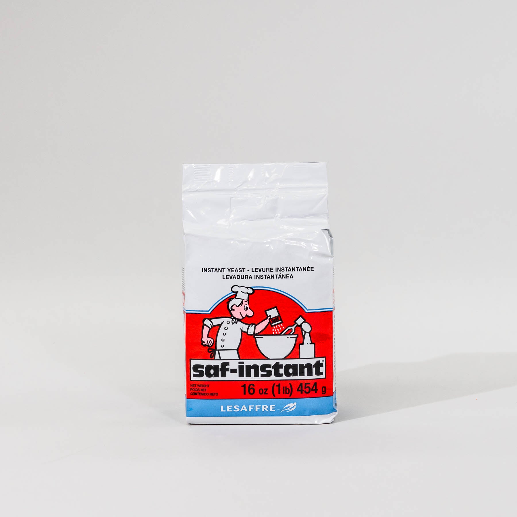 A package of SAF Red Label Instant Yeast with a predominantly white label featuring a red logo and a picture of a chef.