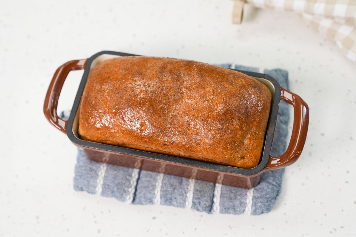 Freshly baked Ezekiel bread sliced on a wooden cutting board, showing a soft crumb and hearty texture.