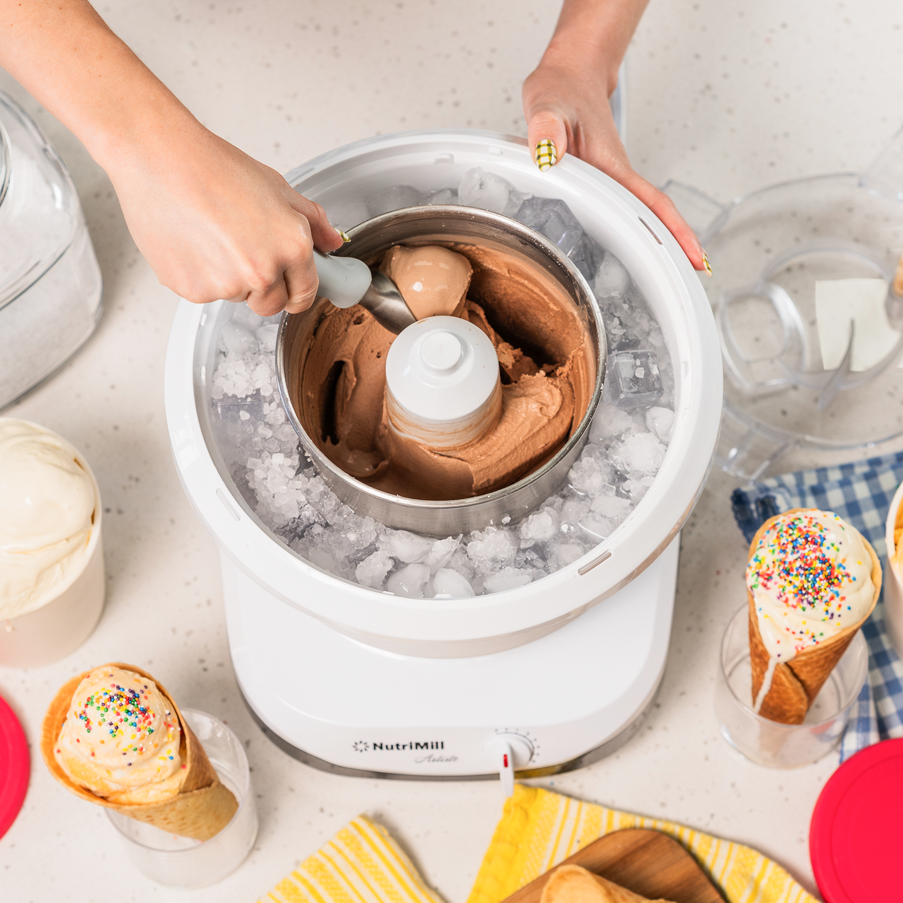 Overhead view of a hand scooping chocolate ice cream from a NutriMill Artiste ice cream maker