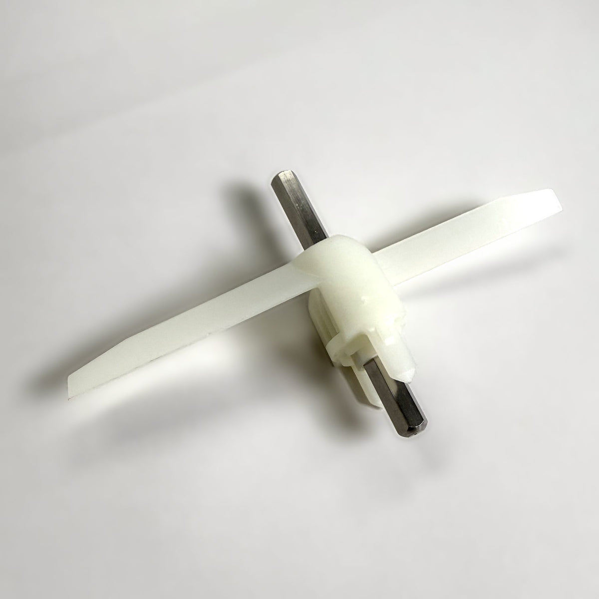 Replacement slinger for the Bosch Compact Continuous Slicer Shredder MUZ4DS4, with white plastic blades and a steel hex shaft, on a grey background
