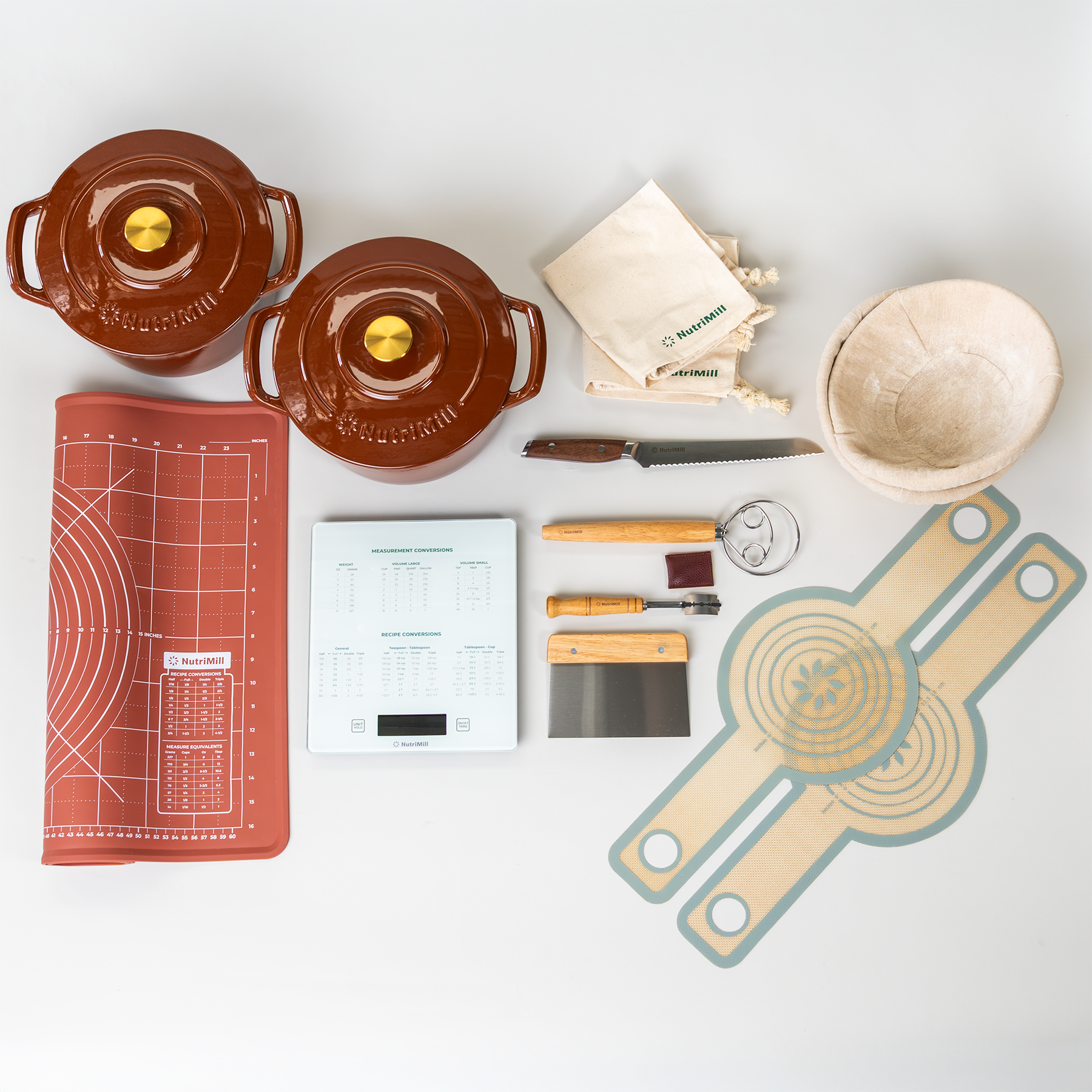 Collection of kitchen items including pots, a knife, a sourdough kit, a rust-colored dough mat, a kitchen scale, and sourdough slings on a grey counter