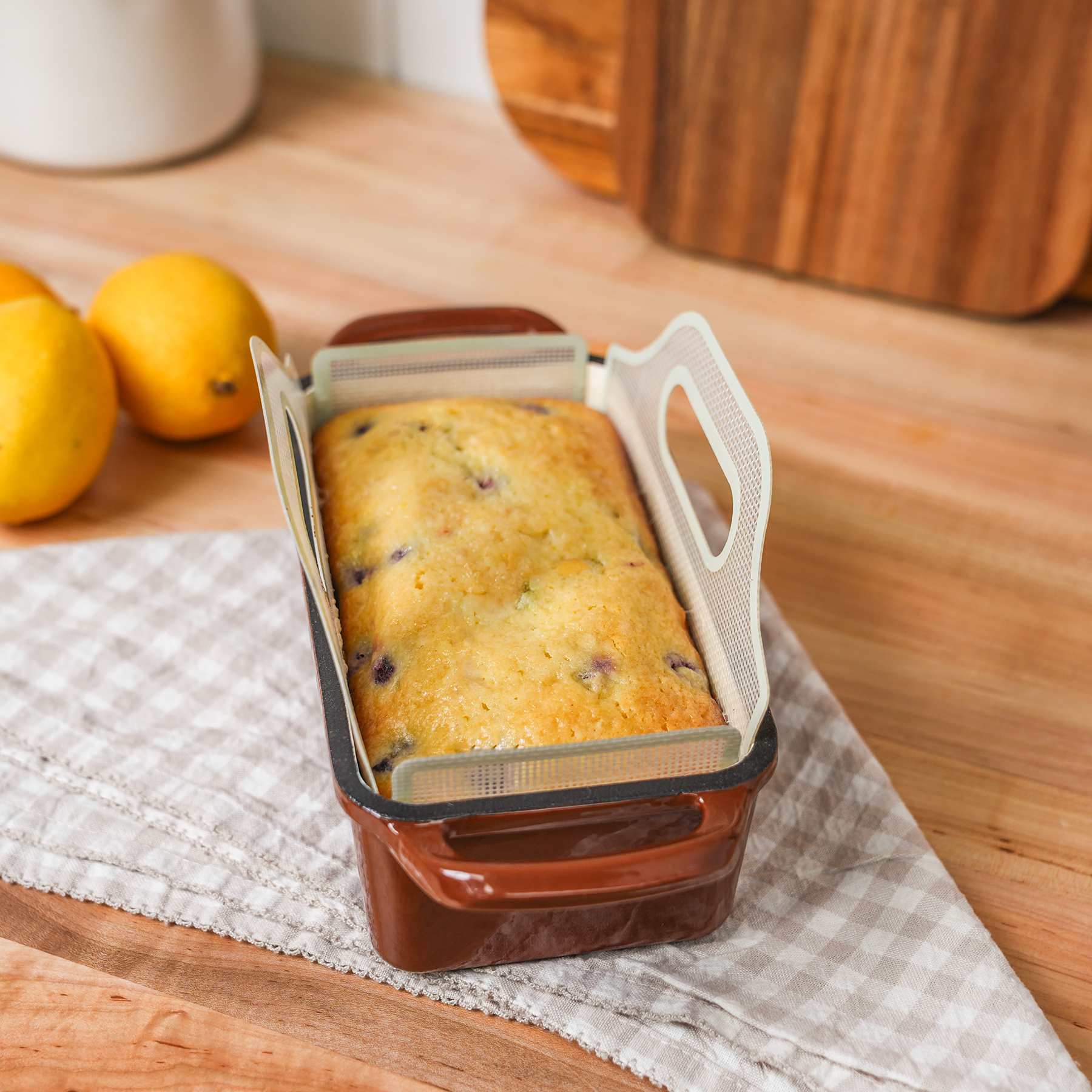Lemon blueberry loaf in a ceramic bread pan on a wooden counter