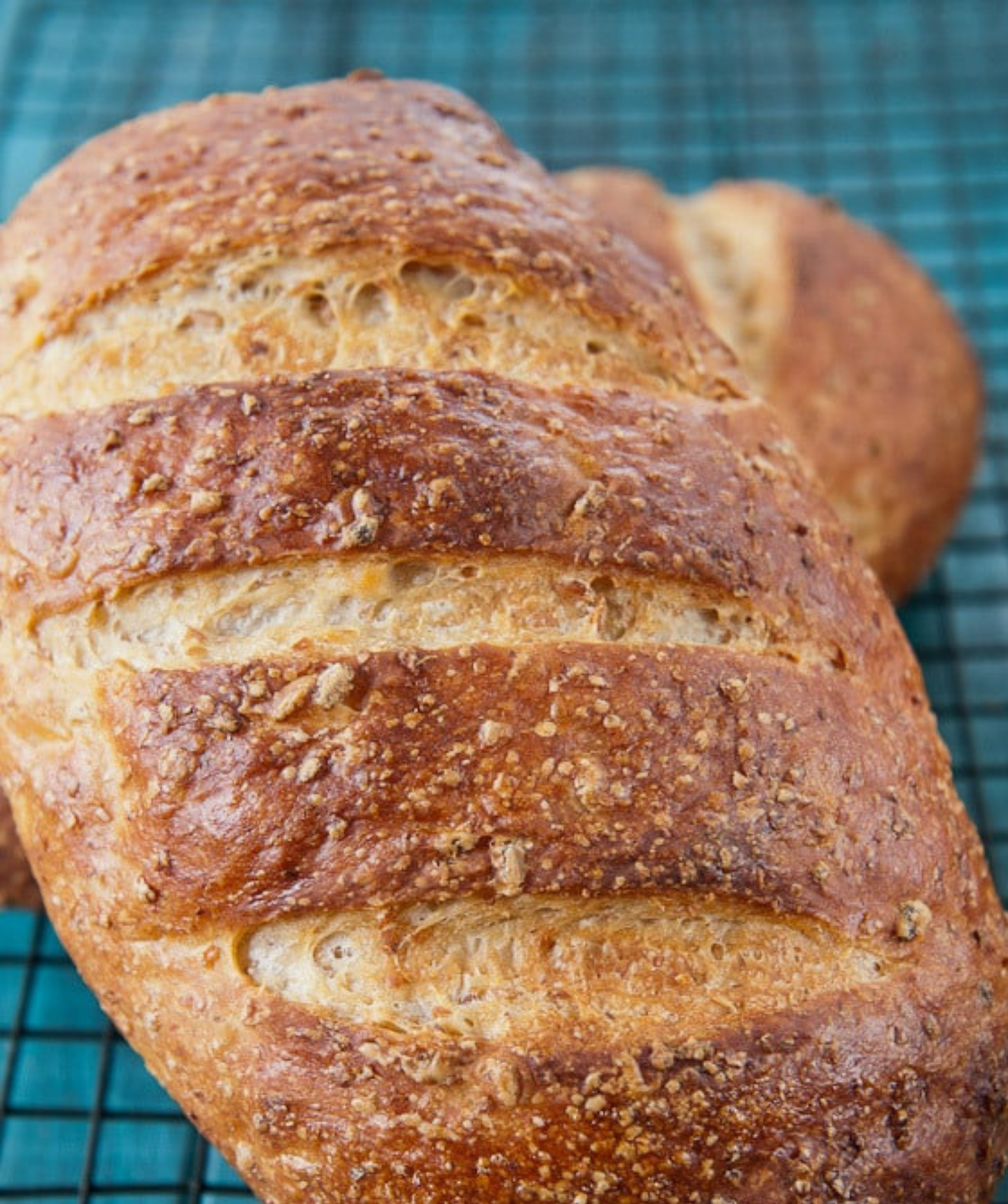 Loaves of artisan rye bread cooling on a wire rack