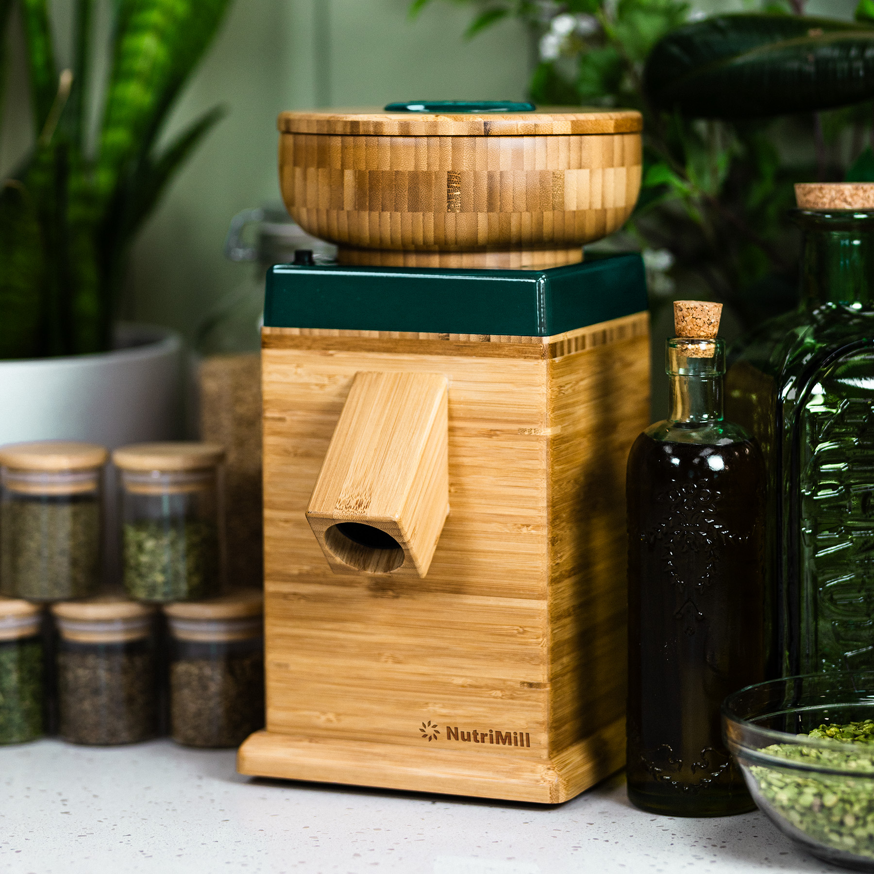 NutriMill Harvest Grain Mill with green trim surrounded by ingredients