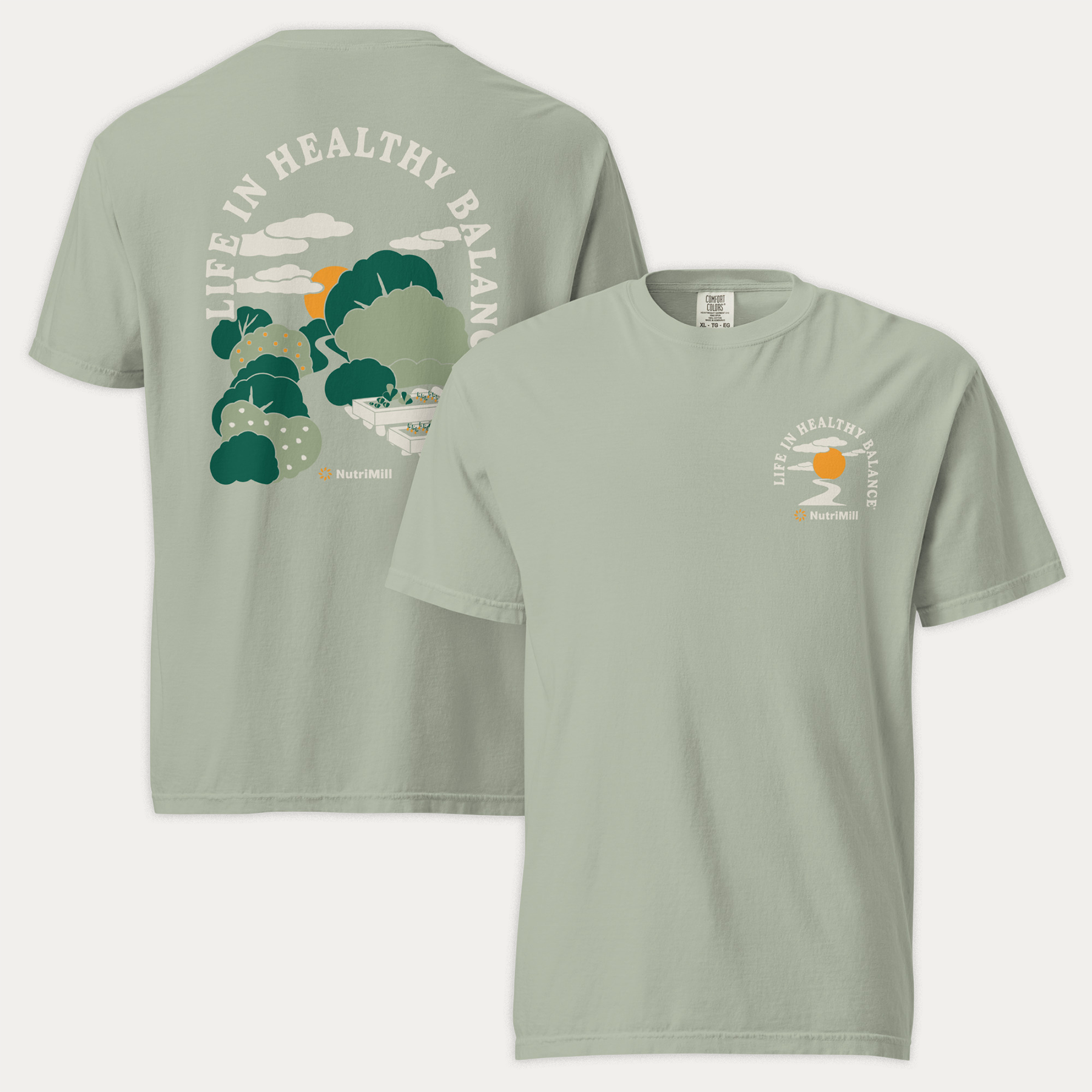 Front and back view of a sage green NutriMill 'Life in Healthy Balance' unisex garment-dyed heavyweight t-shirt with garden landscape illustration