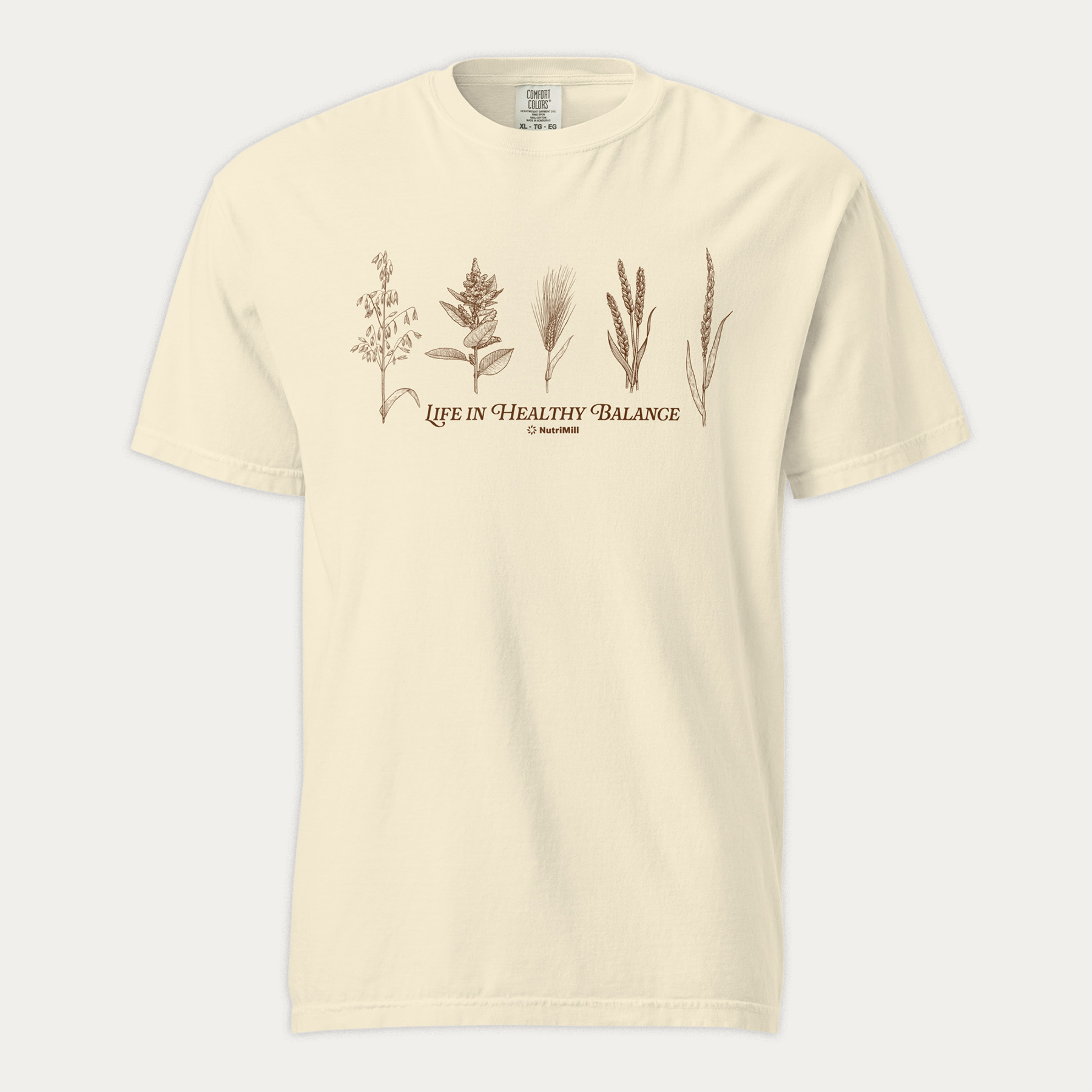 Front view of an ivory NutriMill 'Life in Healthy Balance' unisex garment-dyed heavyweight t-shirt with brown wheat and grain illustrations