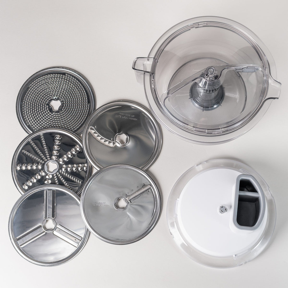 NutriMill Prep & Pour Bundle flat lay with the 6.5 qt clear mixing bowl, Large Slicer Shredder lid, and five stainless steel disks including the French fry and julienne disks