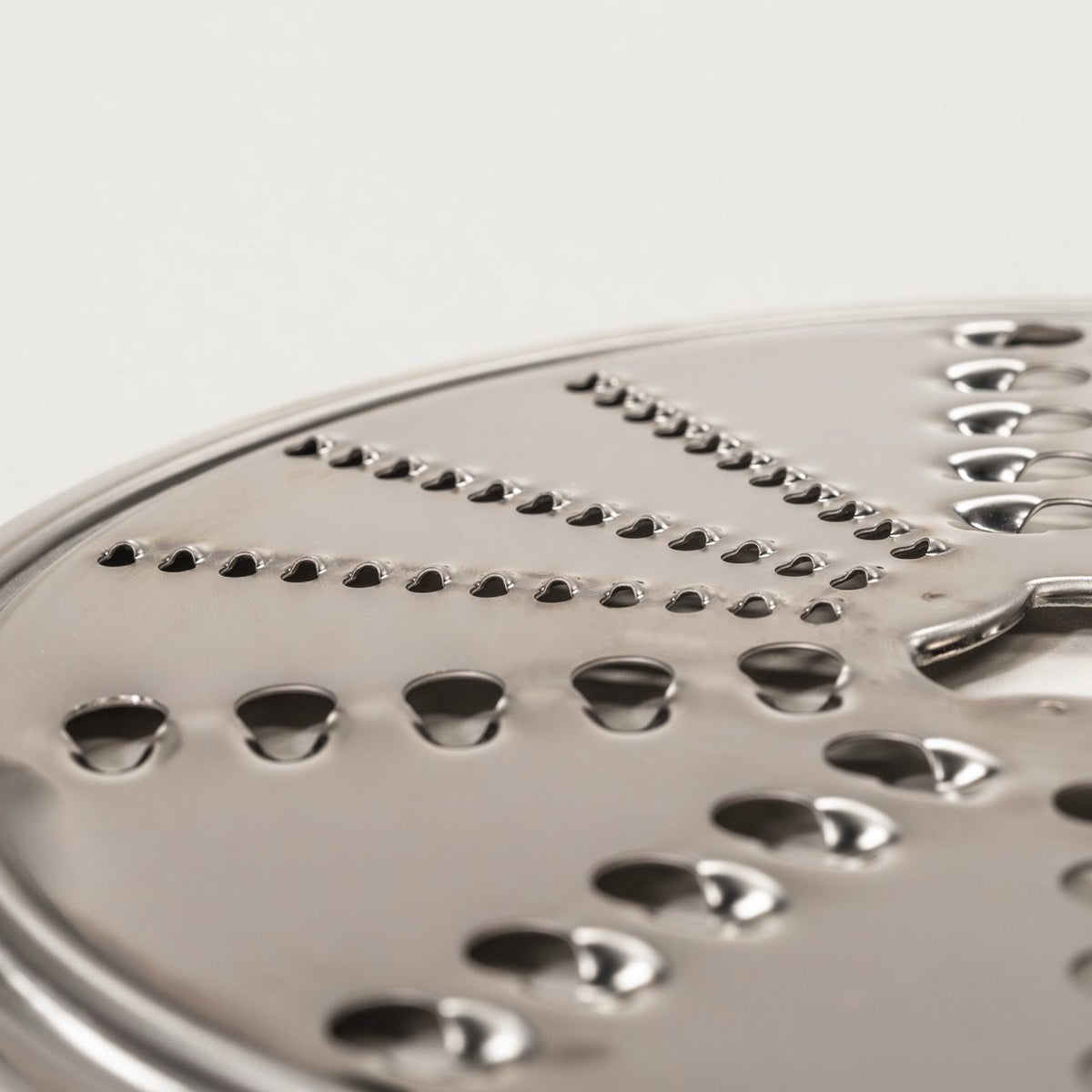 Close-up of the reversible shredding disk showing coarse and fine shredding holes